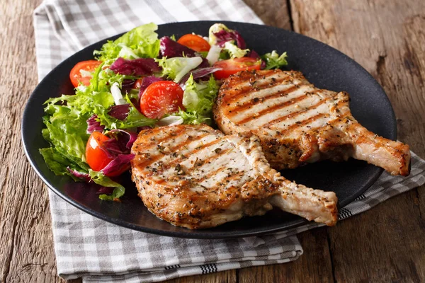 Grilled pork steak with bone, fresh vegetable salad close-up. Ho — Stock Photo, Image