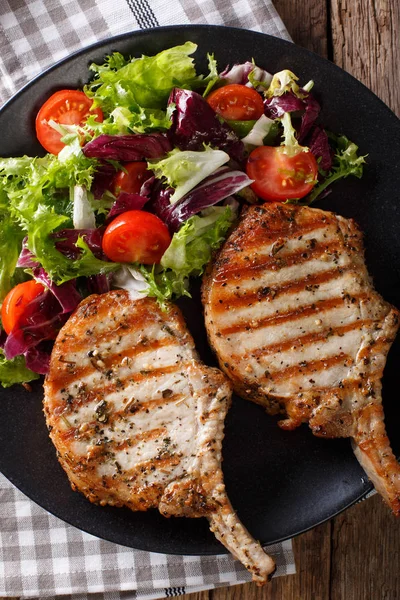 Grilled pork steak with bone, fresh vegetable salad close-up. Ve — Stock Photo, Image