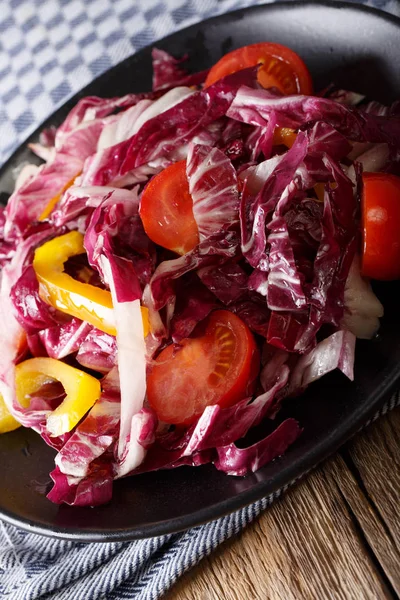 Vegetarian salad of radicchio, tomatoes and pepper closeup. vert — Stock Photo, Image