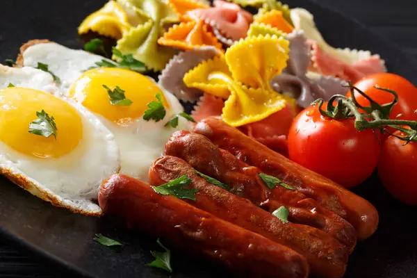 Breakfast: fried egg, sausages, farfalle pasta and tomatoes clos — Stock Photo, Image