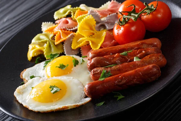 Fried egg, sausages, pasta farfalle and tomato close-up. Horizon — Stock Photo, Image