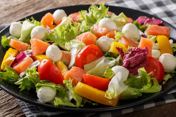 Fresh salad with salted salmon, mozzarella cheese and vegetables