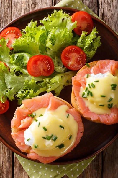 Œufs Benedict au saumon et sauce hollandaise en gros plan. Verticale — Photo