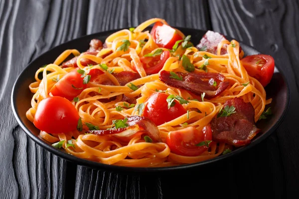 Italian orange pasta with fried bacon, greens and fresh tomatoes — Stock Photo, Image