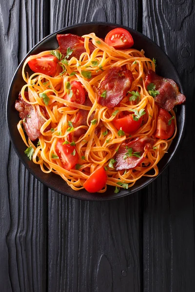 Karottennudeln mit Speck und Tomaten aus nächster Nähe. vertikale Spitze vi — Stockfoto