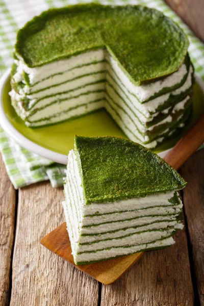 Corte la torta de crepe de espinacas con el primer plano de queso crema. vertical — Foto de Stock