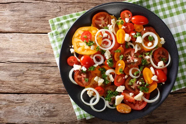 Salade van kleurrijke tomaten, ui en blauwe kaas close-up. Hori — Stockfoto