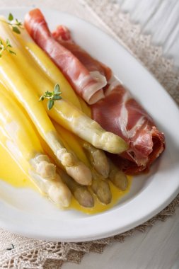 Hollanda sosu ve prosciutto jambonu ile baharatlı beyaz kuşkonmaz kapatın-