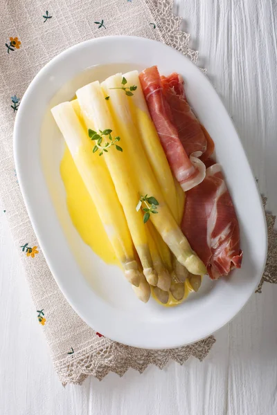 Asperges blanches savoureuses avec sauce hollandaise et jambon gros plan sur — Photo