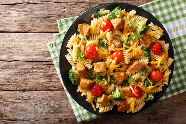 Fusilli pasta med fläskkött, broccoli, tomater och ost cheddar c — Stockfoto