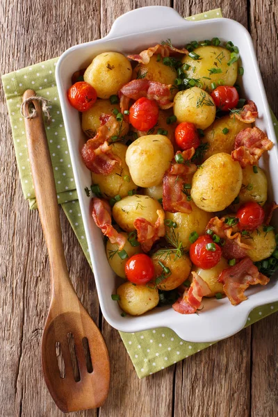 Pieczone młode ziemniaki z boczkiem, zioła i pomidory bliska w — Zdjęcie stockowe