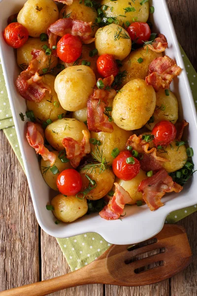 Välsmakande färskpotatis i ugn med bacon, örter och tomater makro i — Stockfoto