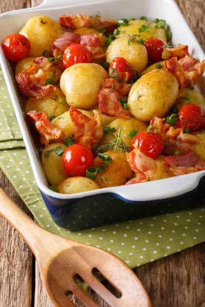 Smaczny młode ziemniaki pieczone z boczkiem, zioła i pomidory bliska — Zdjęcie stockowe