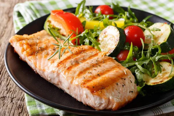 Filé saboroso de salmão grelhado e salada de legumes com rúcula — Fotografia de Stock