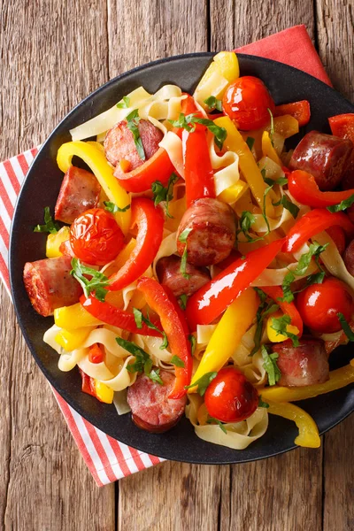 Pasta with stewed bell pepper and sausages close-up on a plate. — Stock Photo, Image