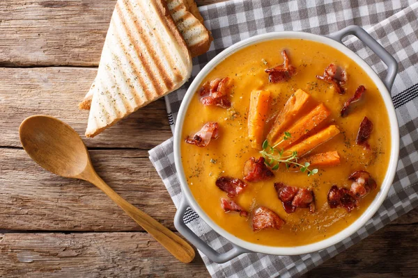 Krémová polévka ze sladkých brambor s kořením a slaninou detail na — Stock fotografie