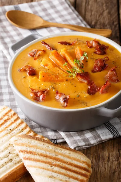 Zdravé sladké brambory krém polévka se slaninou a bylinkami v saucep — Stock fotografie