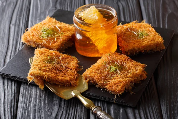 Sweet oriental dessert kunafeh with pistachios and fresh honey c — Stock Photo, Image