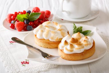 Limon tartlets beze, çilek ve kahve yakın çekim. Yatay