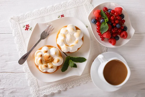 Tarta de limón con merengue y mezcla de bayas, primer plano de café. horizo —  Fotos de Stock