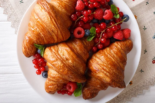 Croissant emas dengan buah musim panas segar close-up di piring . — Stok Foto