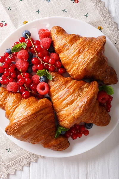 Gyllene croissanter med färsk sommar bär närbild på en tallrik. — Stockfoto