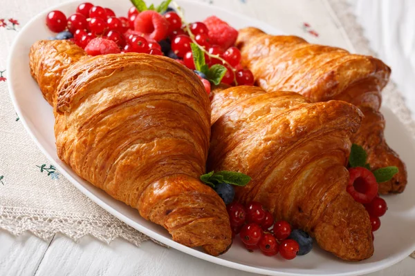 Nybakade croissanter med hallon, blåbär och vinbär cl — Stockfoto