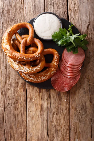 German appetizer: sliced salami and pretzels with sauce close-up Royalty Free Stock Images