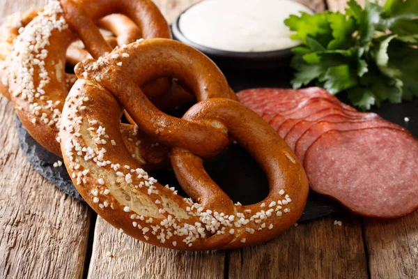 German appetizer: sliced salami and pretzels with sauce close-up Royalty Free Stock Photos