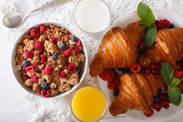 Здоровий сніданок: гранола з ягодами та круасанами, молоко та — стокове фото