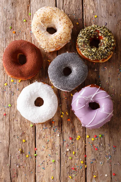 Multicolored donuts with fillings close-up on the table. Vertica — Stock Photo, Image