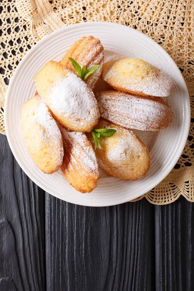 French biscuit Madeleine close-up on a plate on the table. Verti — Stock Photo, Image