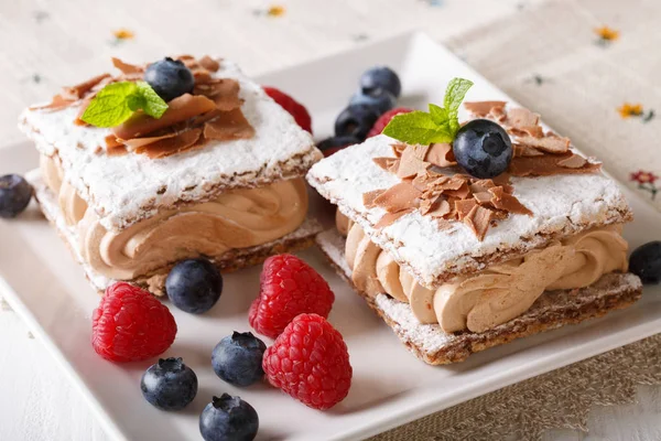 Chocolate millefeuille with coffee cream, raspberries and bluebe — Stock Photo, Image
