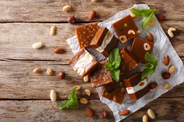 Masanın üzerine fındık yakın çekim ile karamelli şeker. Yatay üst VI