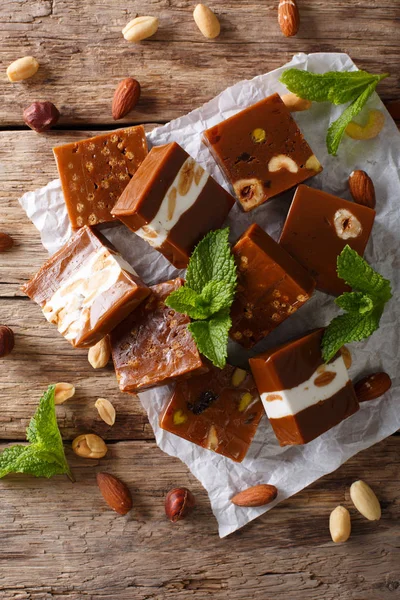 Masanın üzerine fındık yakın çekim ile karamelli şeker. Dikey Üstten Görünüm