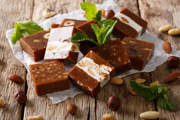 Square sweets toffee with nuts decorated with mint closeup. hori — Stock Photo, Image