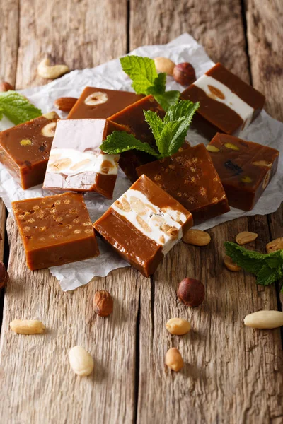 Dulces de caramelo suave con nueces decoradas con primer plano de menta. vertical —  Fotos de Stock