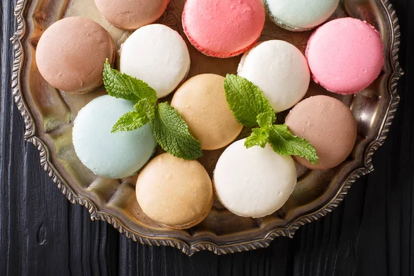 Beautiful French macaroons close-up on a platter. horizontal top — Stock Photo, Image