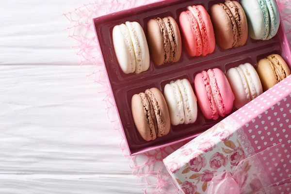 Beautiful macaroons in a pink gift box close-up on a table. Hori — Stock Photo, Image