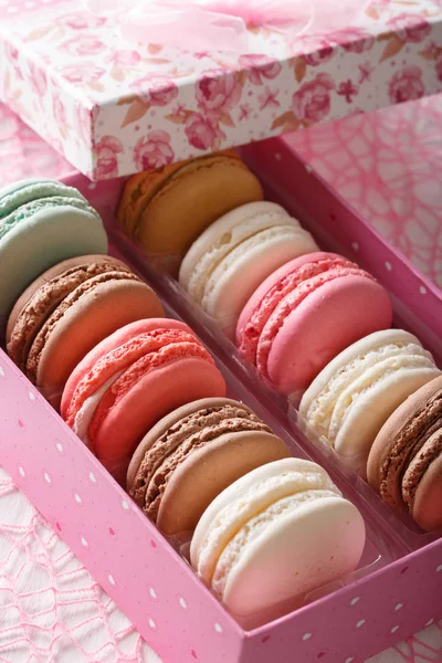 Delicious macaroons in a pink gift box macro on a table. vertica — Stock Photo, Image