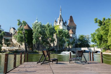 V manzarasına sahip park alanındaki göl kenarında dinlenmek için bir yer