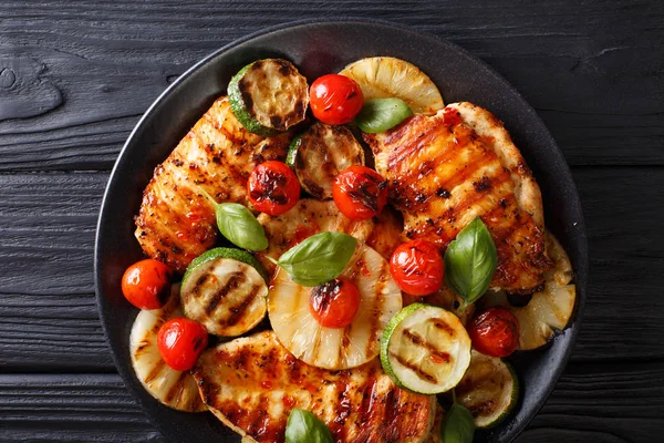 Chicken fillet grilled with pineapple, zucchini and tomatoes in — Stock Photo, Image