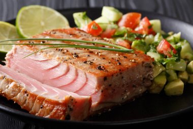 Kireç ton balığı ızgara bir plaka üzerinde avokado salatalık Salsa closeup ile
