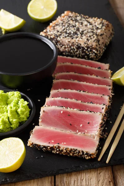Sliced tuna steak in sesame and soy sauce, wasabi, lime closeup. — Stock Photo, Image