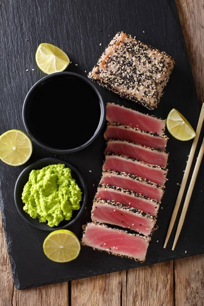 Fresh tuna meat in sesame and soy sauce, wasabi, lime closeup. T — Stock Photo, Image