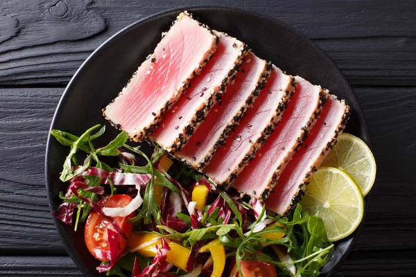 Красива їжа: стейк тунець в кунжуті, лайм і свіжий салат близько — стокове фото