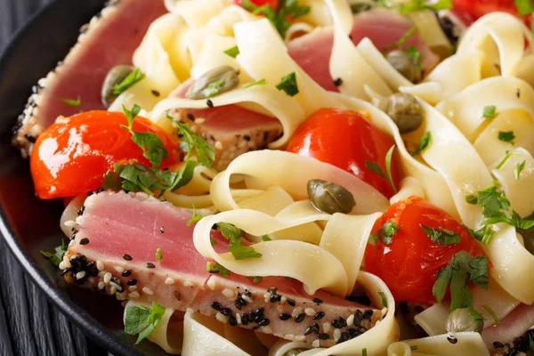 Pasta fettuccine con bistecca di tonno, pomodori e capperi macro. hor — Foto Stock