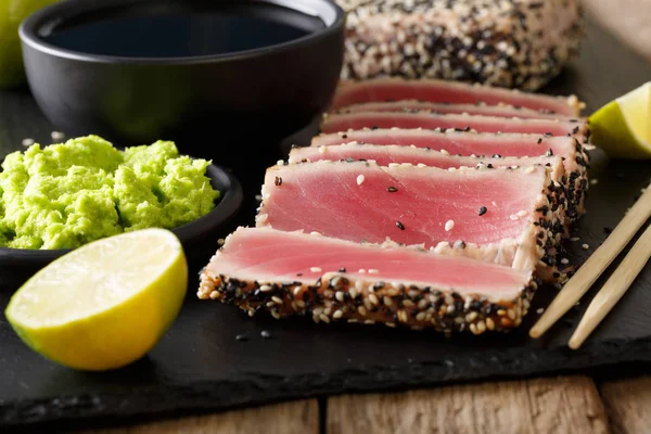 Tuna fillet in sesame and soy sauce, wasabi, lime closeup in Asi — Stock Photo, Image