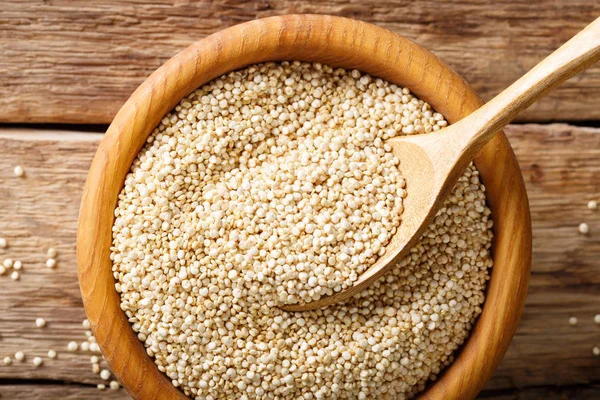 Hagyományos nyers quinoa közelről egy fa tálat az asztalra. t — Stock Fotó