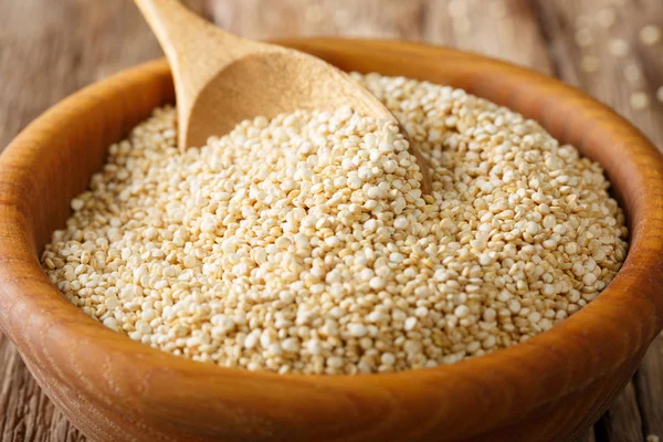 Quinoa cru tradicional fechar em uma tigela de madeira sobre a mesa. H — Fotografia de Stock